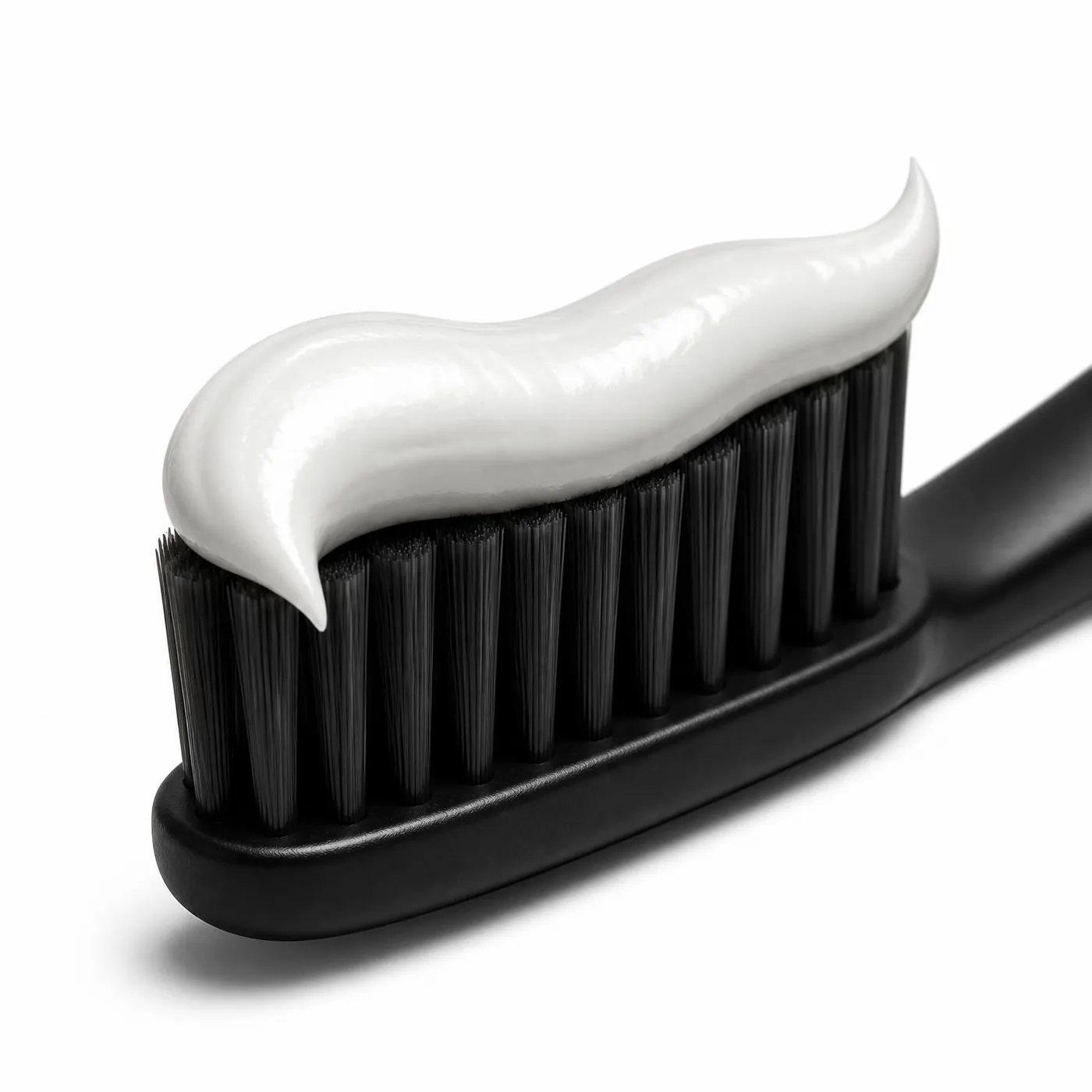 A ribbon of NIMA whitening toothpaste on a black toothbrush